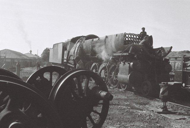 A wheel set from a previously cut up 15F lies discarded, while her fellow mate is receiving the scrappers' attention, and soon this wheel set will be joined by others.