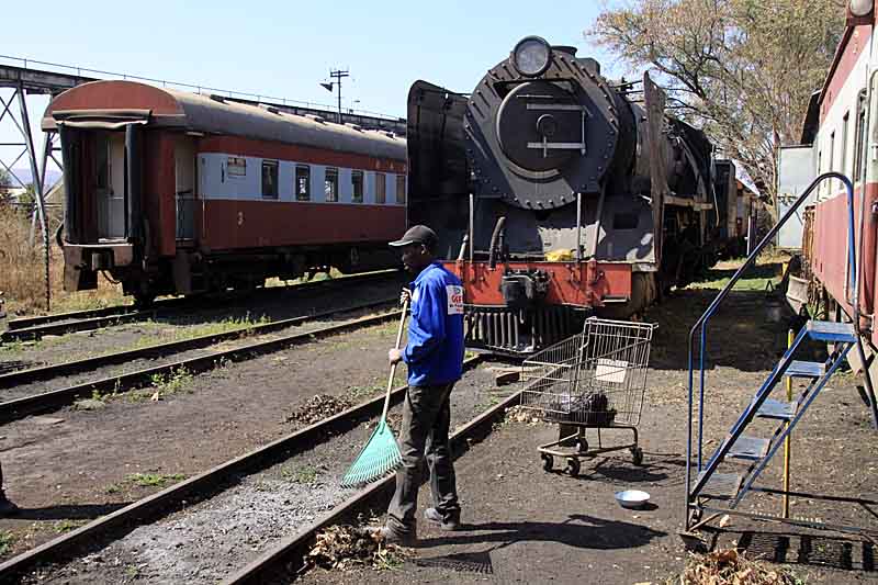 John Makopo finishes off the gardening near to Spikkels' caboose, watched over by 3117