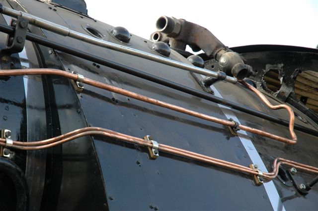 As good as any coppersmiths work, the beautifull lines of annealed piping lie freshly placed on the boiler of 3117. You an clearly see how bakelite spacers have been placed behind the pipe clamps to prevent the accumulation of soot which would eventually lead to rust damage. It also makes pipe polishing an easier task.