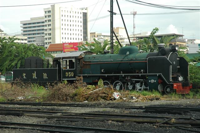 Pacific locomotives belonging to the class 900 series. They were a batch of 70 locomotives 2-8-2 (Mikado). Built by Hitachi in 1950 as wood burners, but later converted to oil burning. They were used for goods and mixed trains on the Northern and Northeastern lines. Withdrawn in 1982. There is an operational one at this depot at Thonburri, Bangkok. This loco is dumped at the entrance to the depot