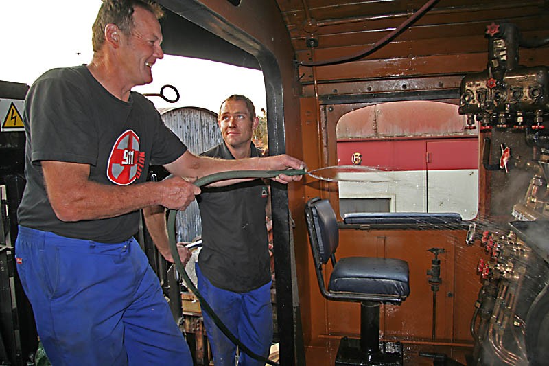 Les wields the hose while Dewald looks bemused
