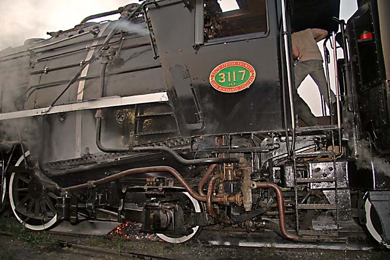 Nathan works the hand shaker, the fire drops onto the track below, and 3117 glints in the late afternoon sun